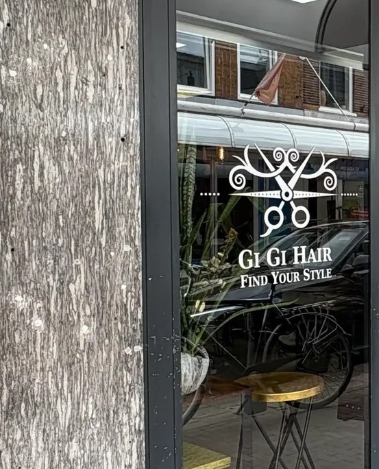 De etalage van Gi Gi Hair met het logo op het glas