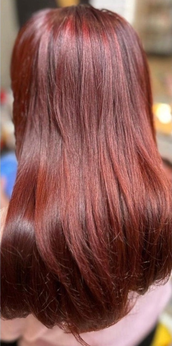Glanzend bordeauxrood lang haar na het kleuren, van achteren gezien